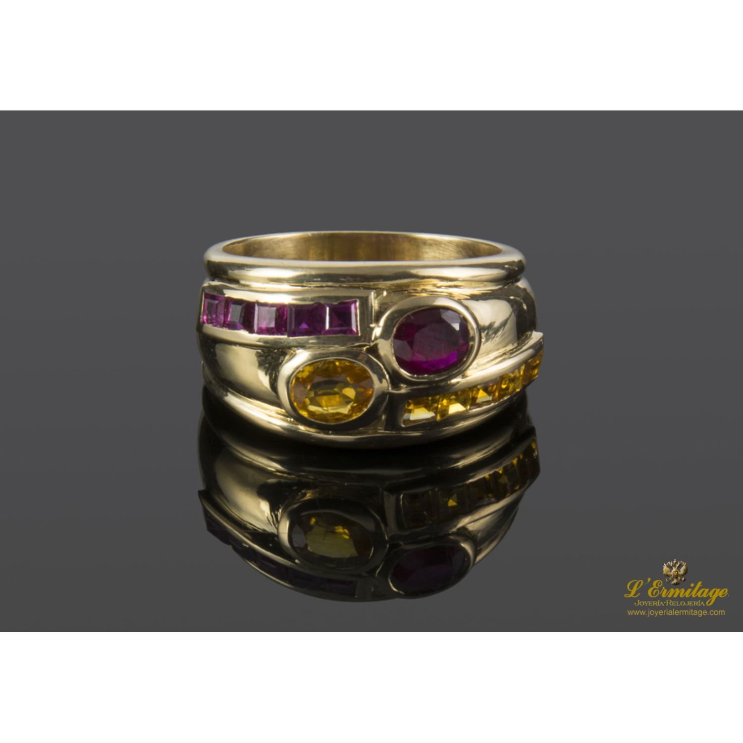 Sortija realizada en oro amarillo y motivos con topacios y rubíes.