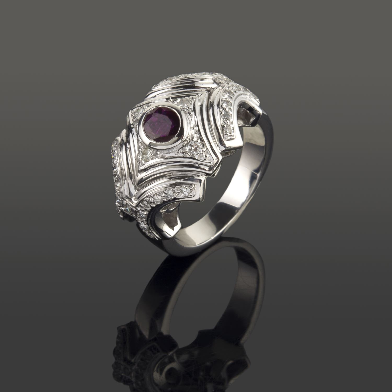 Sortija en oro blanco. Presenta un rubí natural y  motivos con brillantes