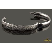 Pulsera rígida de media caña con centro pabe de brillantes montados en oro blanco.