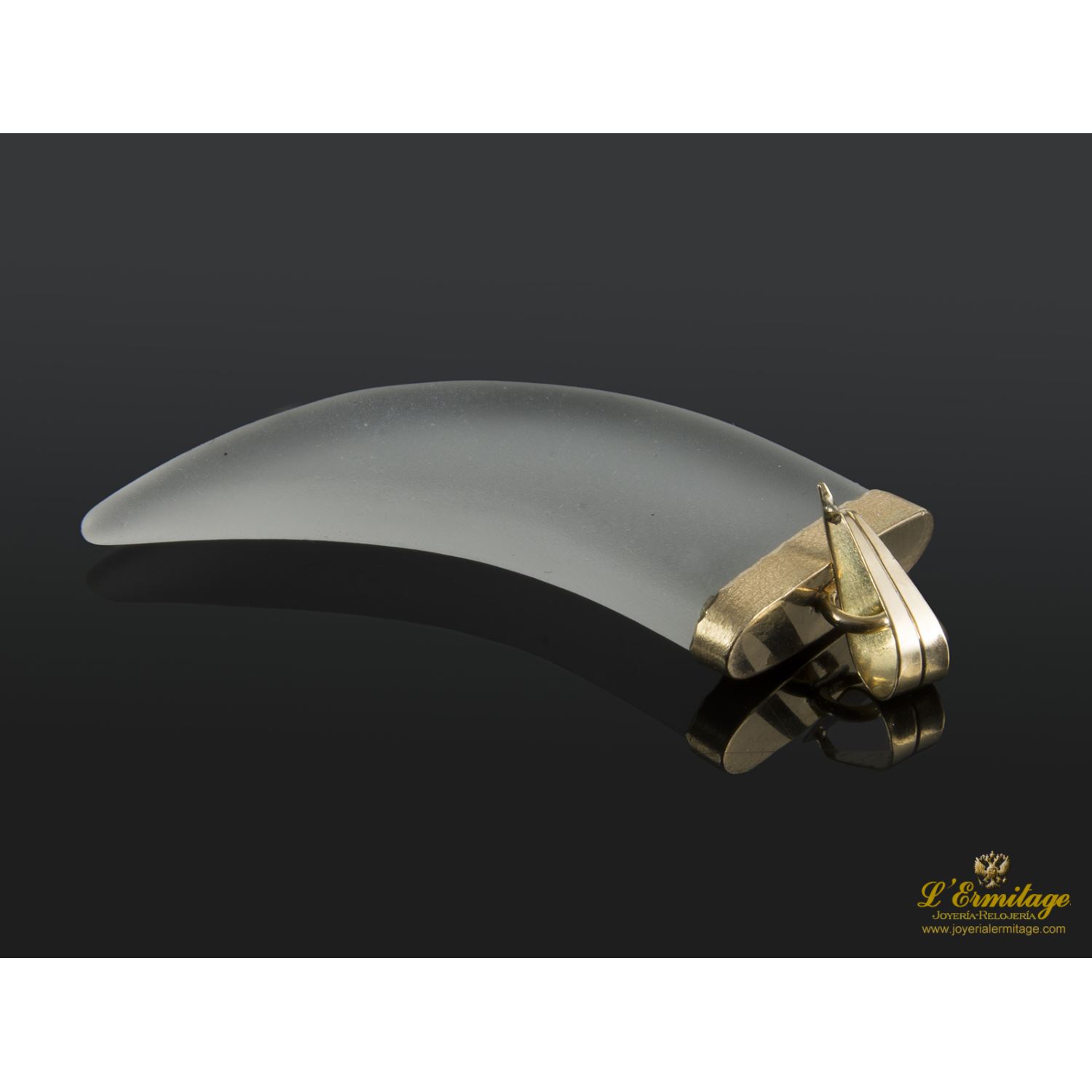 Colgante con cuarzo hialino en forma de colmillo montado en oro amarillo.