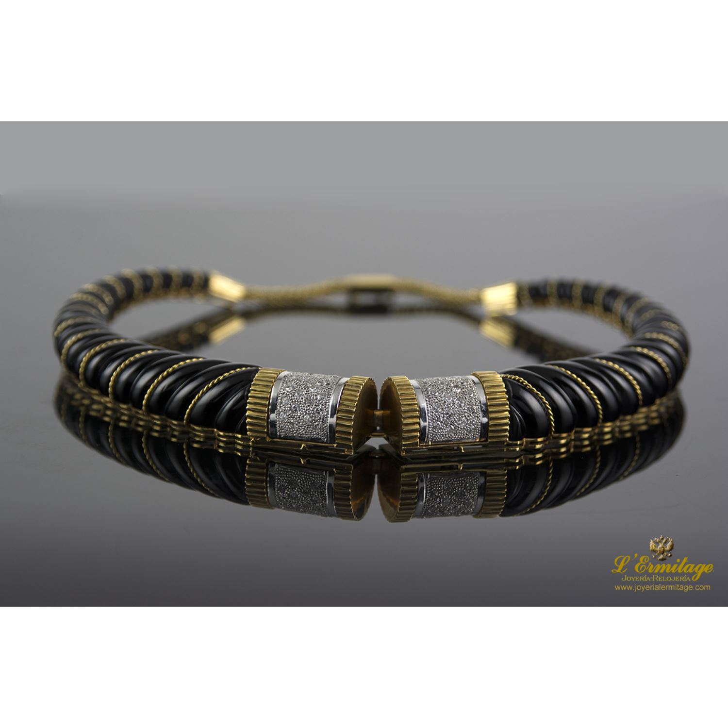 Collar rígido realizado en oro amarillo, oro blanco, onix y brillantes.