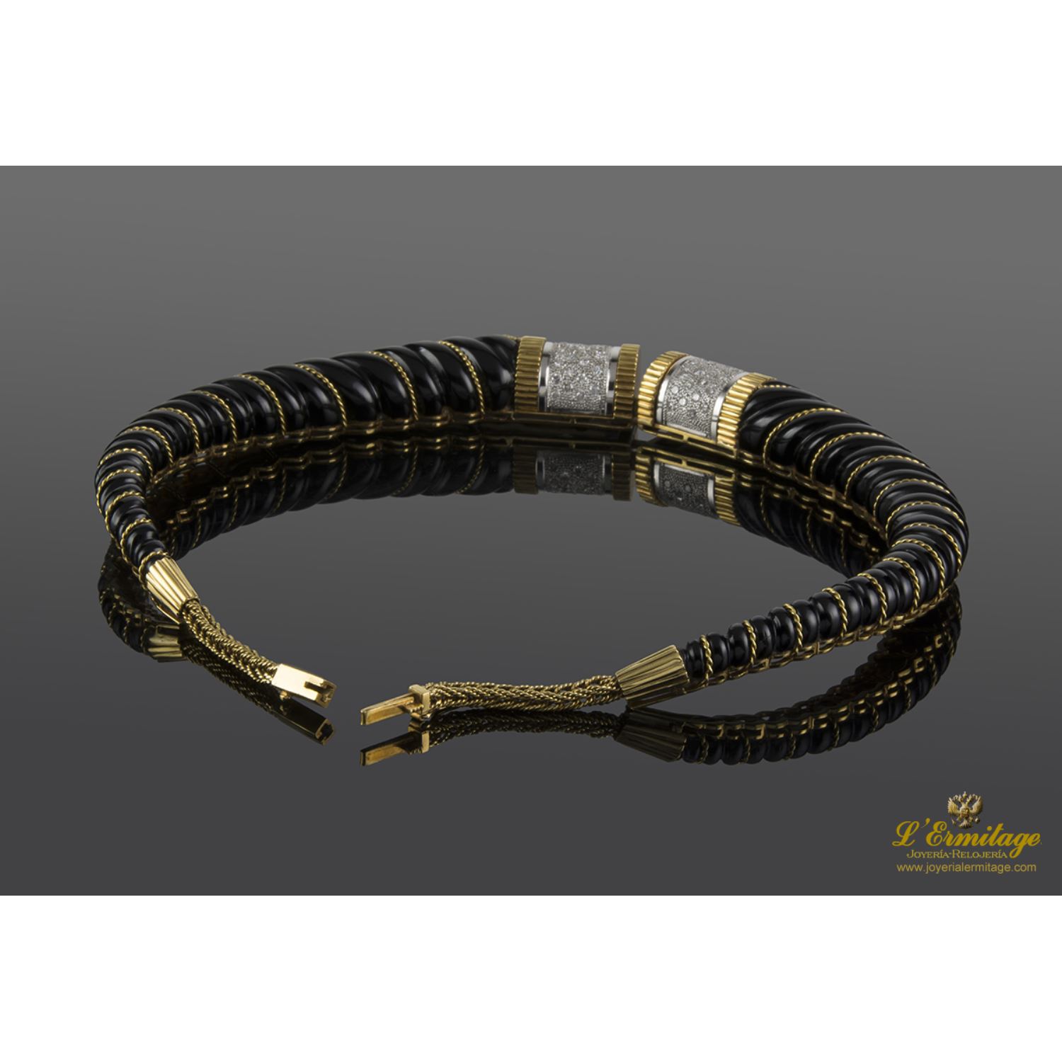 Collar rígido realizado en oro amarillo, oro blanco, onix y brillantes.