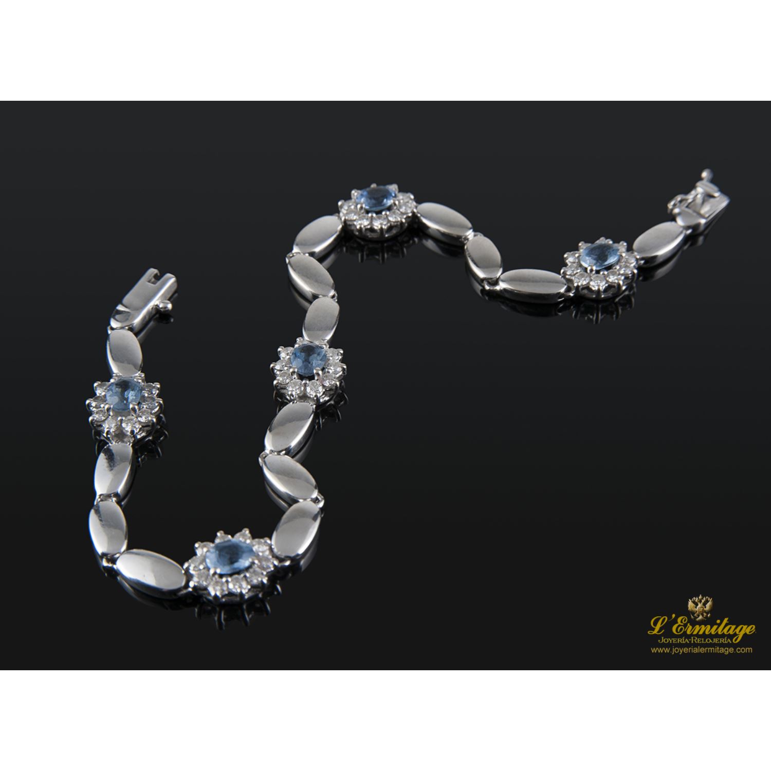 Pulsera realizada en oro blanco con rosetas de agua marina y brillantes.