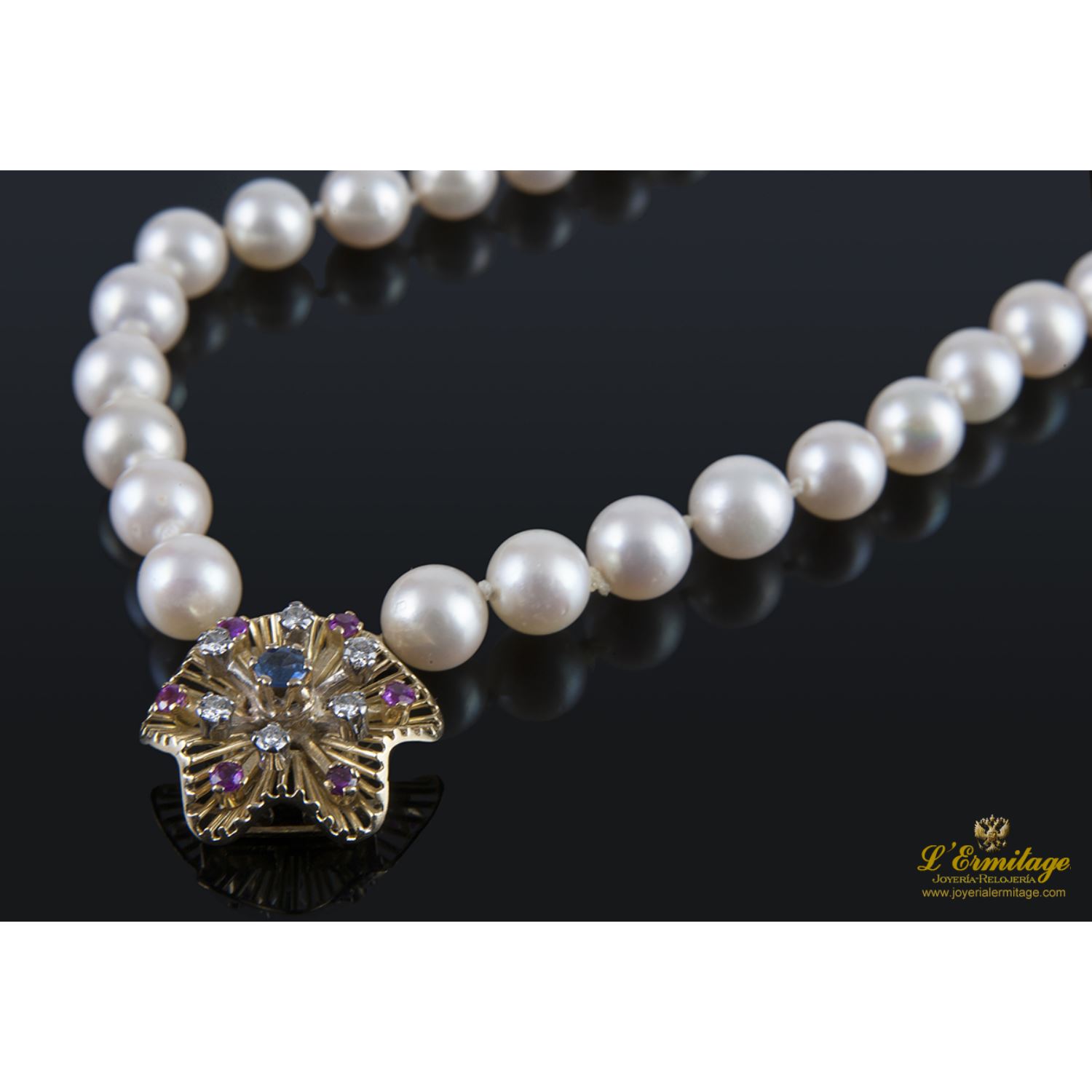 Pulsera de perlas con cierre en oro amarillo con forma de flor.