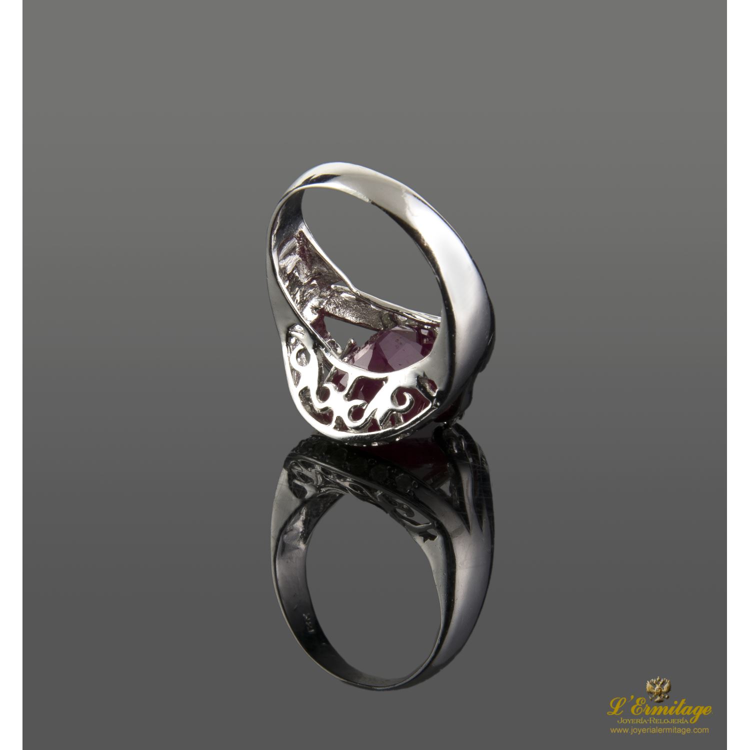 Sortija en oro blanco con rubi central y brillantes.