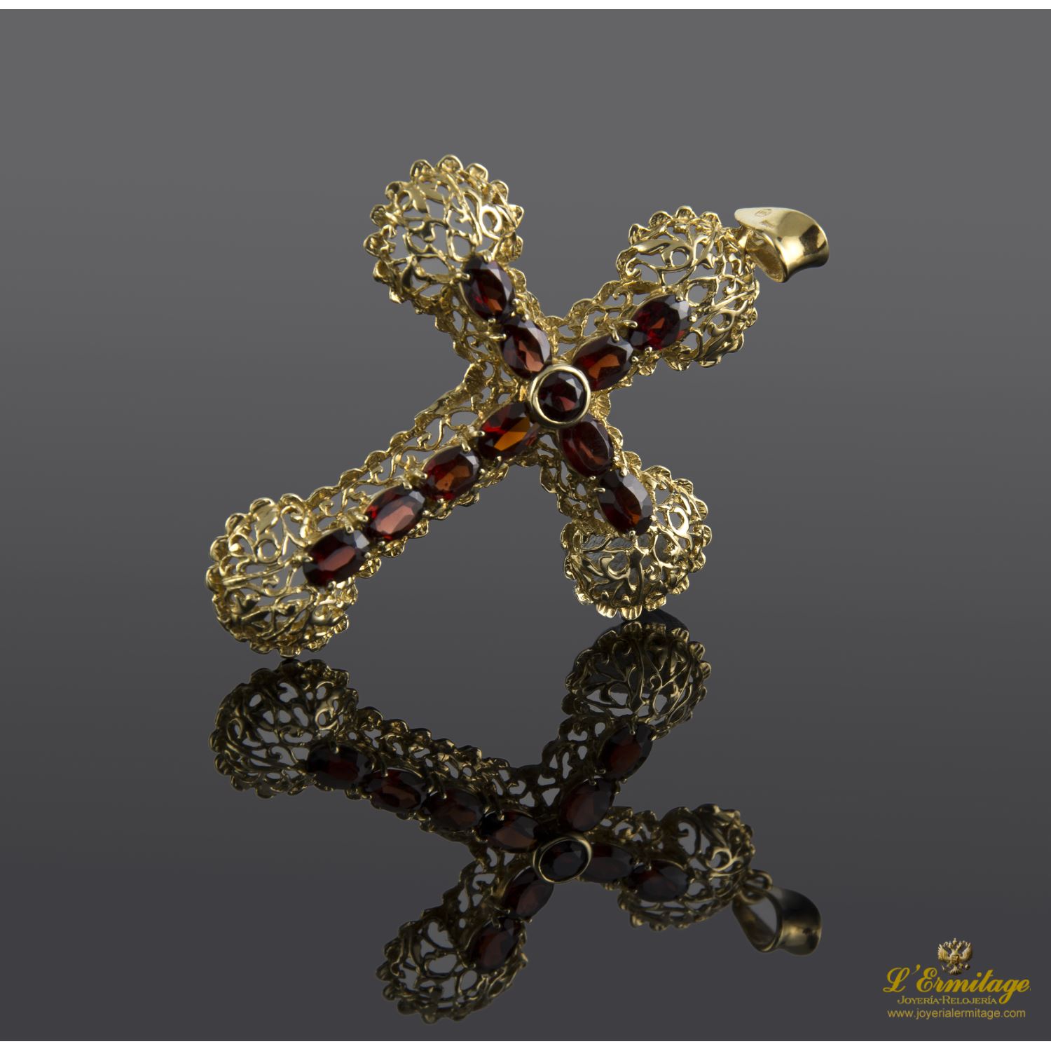 Colgante en forma de cruz en oro amarillo con granates.