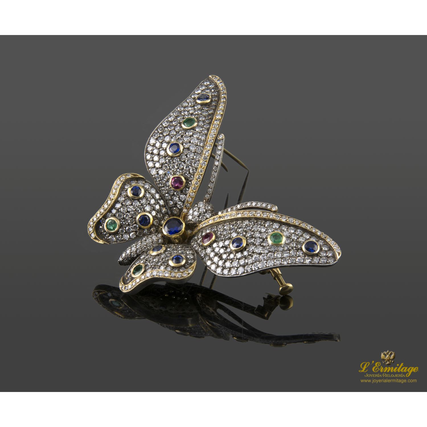 Broche-alfiler mariposa en oro amarillo y plata con rubíes, esmeraldas, zafiros y diamantes naturales.