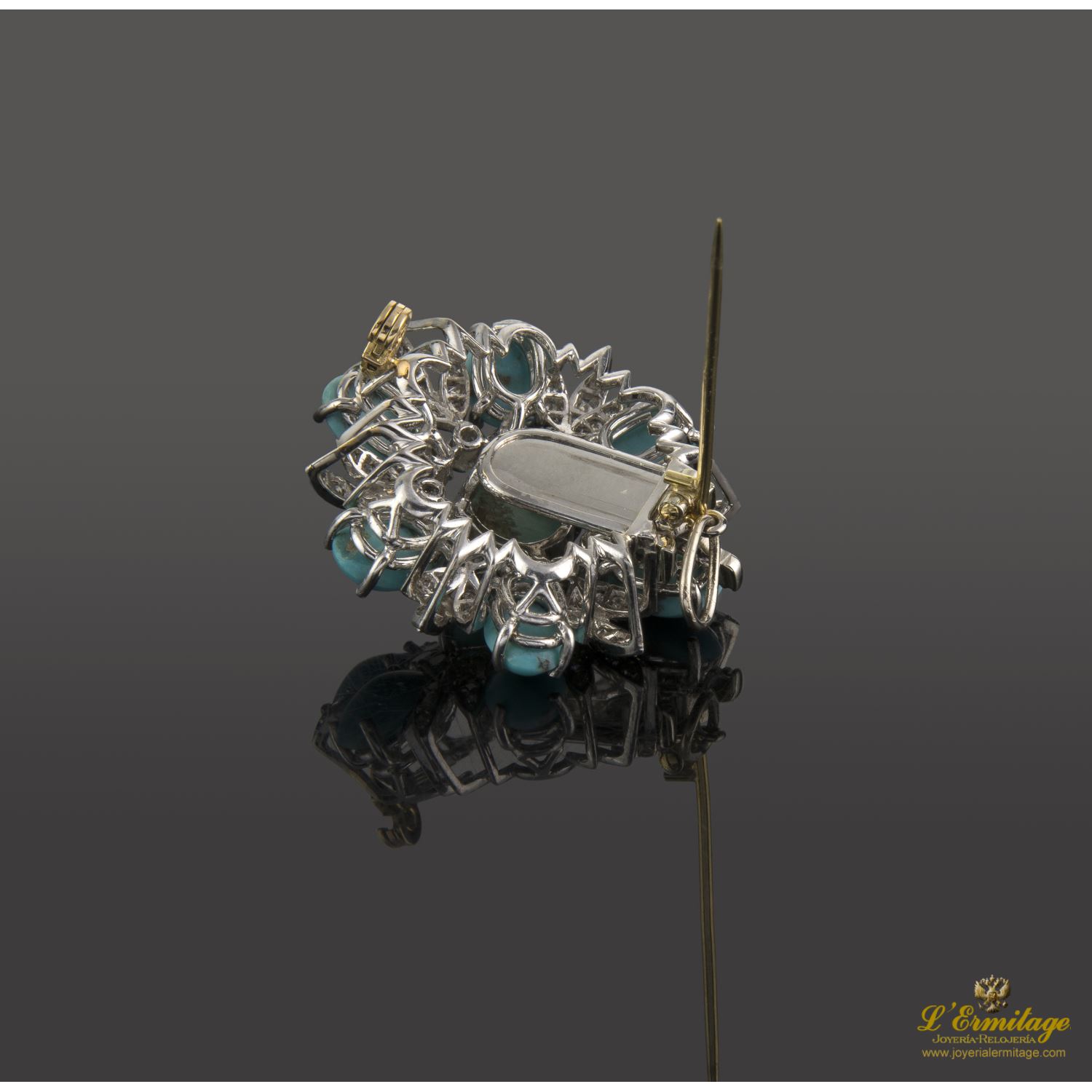 Broche en forma de flor oro blanco turquesas y diamantes.