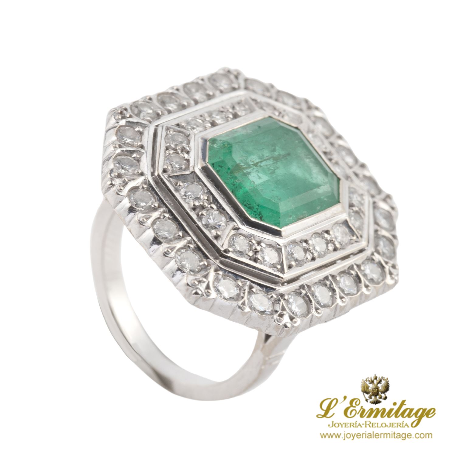 Sortija en oro blanco con esmeralda central y brillantes.