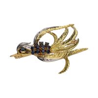 Broche con forma de fénix en oro amarillo con zafiros y diamantes.