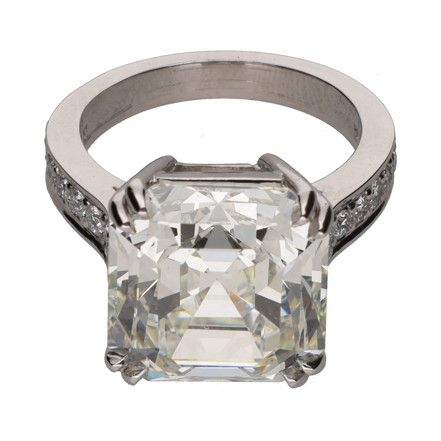 Sortija en platino con diamantes talla esmeralda central y brillantes.