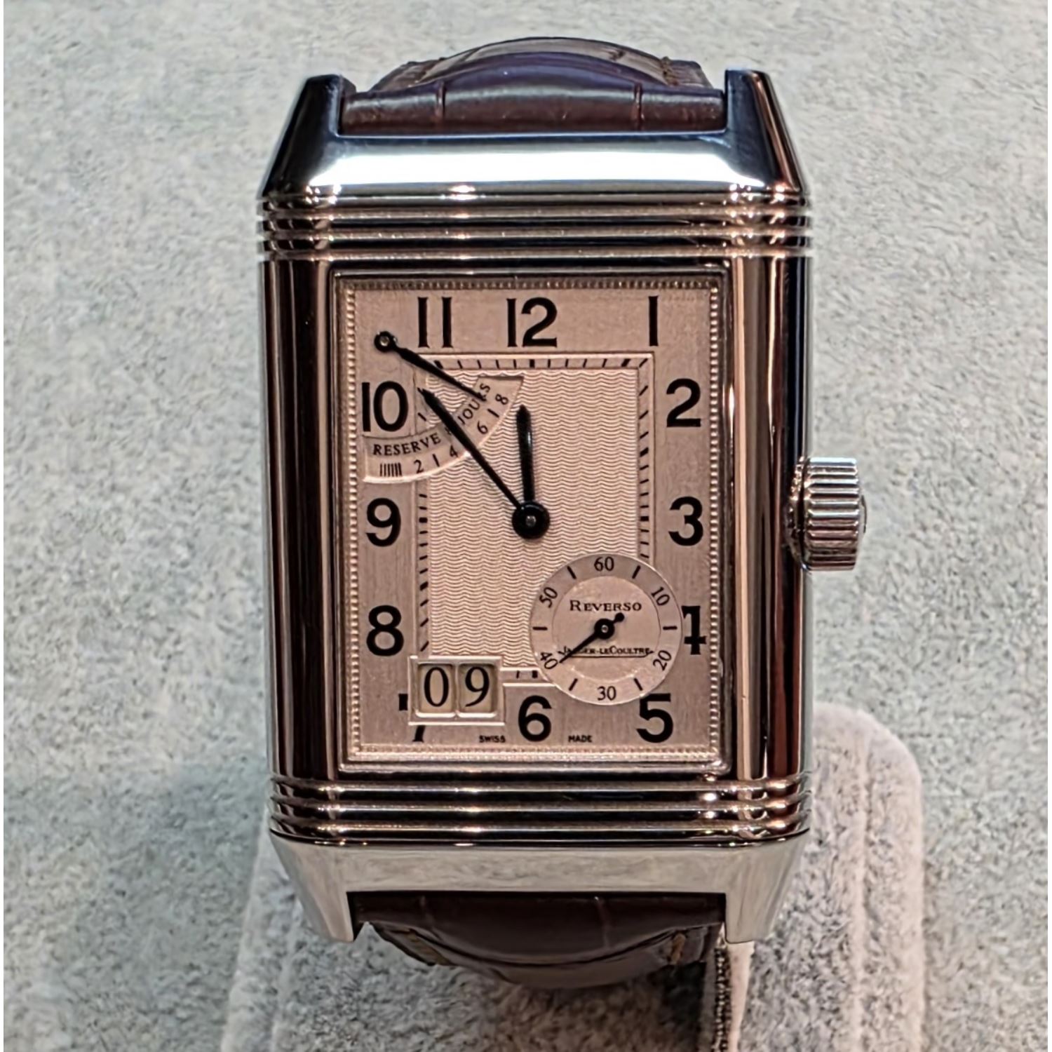 Reverso grande date reserva de marcha acero cuerda manual.  